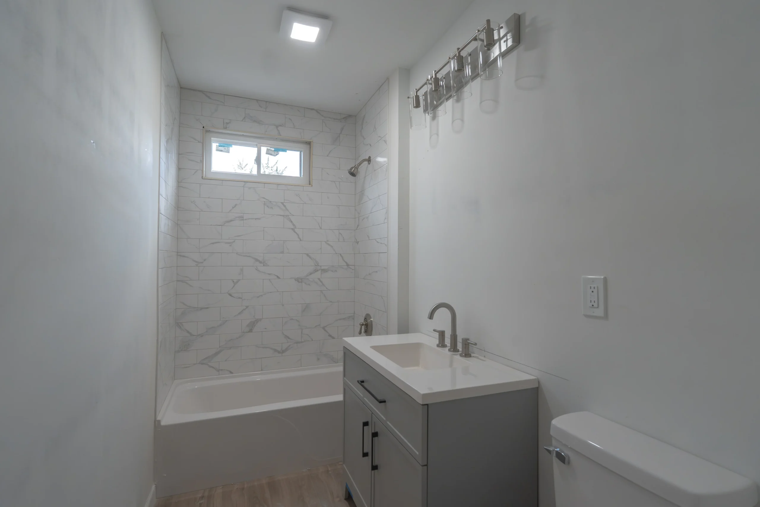 New marble tile bathroom after damage restoration - Hemlock Street